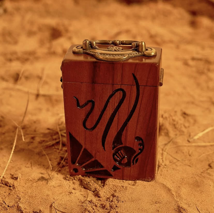 The C-box ankyem wooden bag, a compact hand-carved walnut case in a Rosewood finish, by Phyll Quahsey.