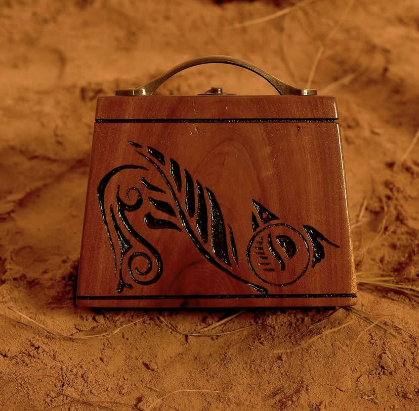 The Plume Case, a hand-carved walnut wood case with feather-like carvings and a Teak finish, by Phyll Quahsey.