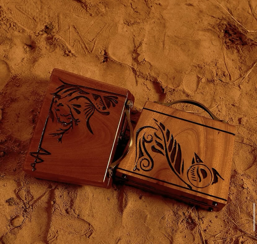 The D’boss ankyem wooden bag, a hand-carved walnut case with a Mahogany finish and brass hardware, by Phyll Quahsey.