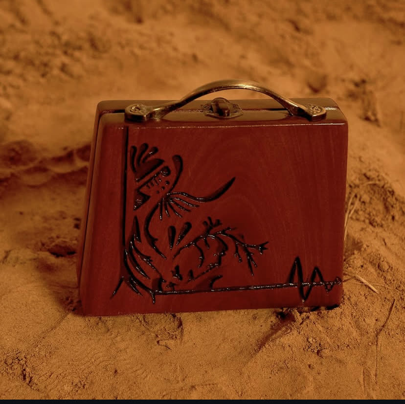The Handle Trunk, a hand-carved walnut wood case with a brass handle and Sienna finish, by Phyll Quahsey.